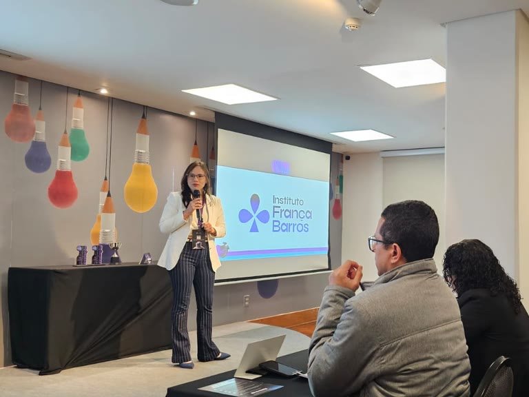 Treinamento do Instituto França Barros, com a marca projetada no telão, diante de uma plateia de profissionais